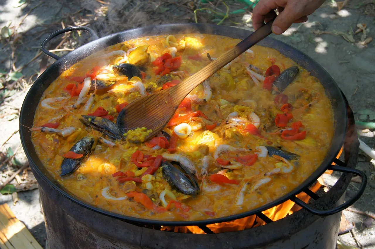 Foto de archivo: sartén de paella humeante al fuego