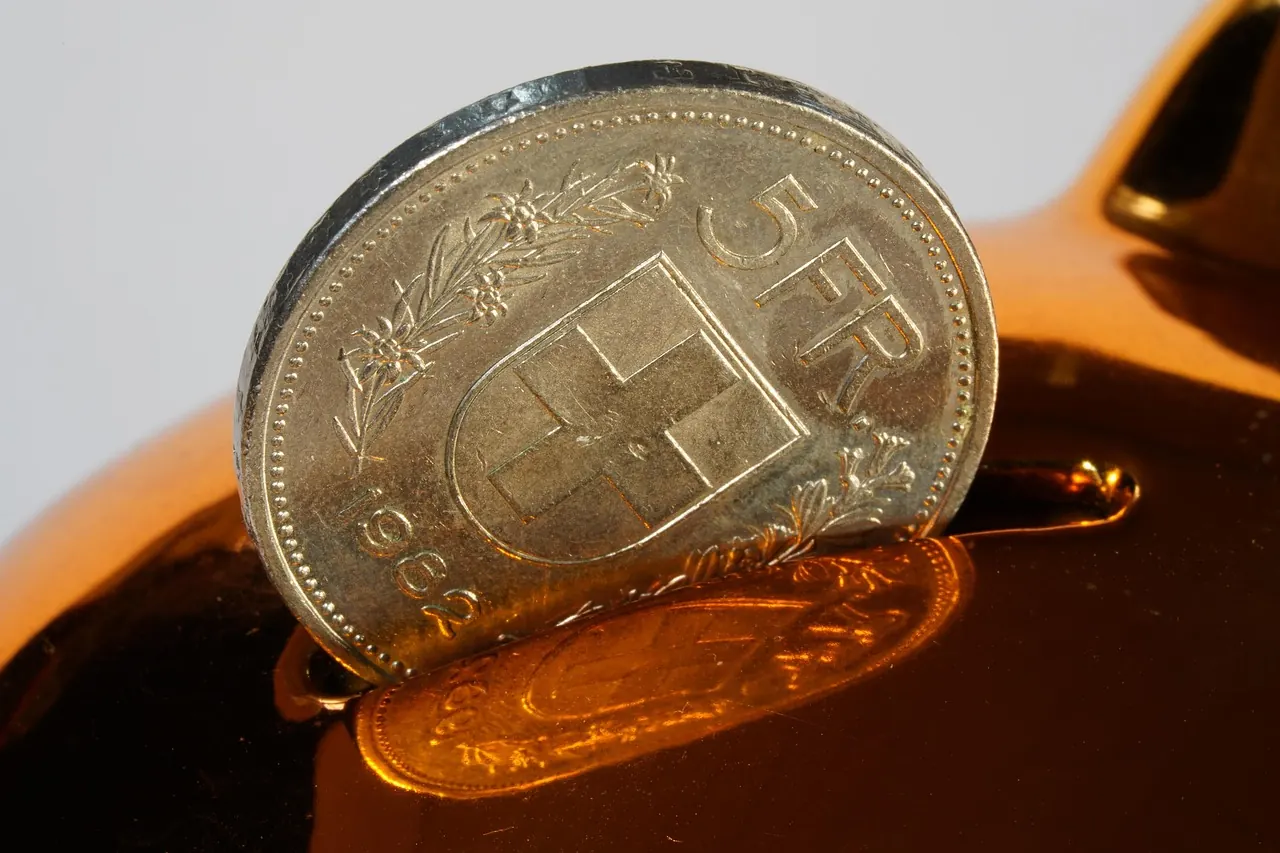 Foto de archivo: hucha de cerdito con monedas ahorradas