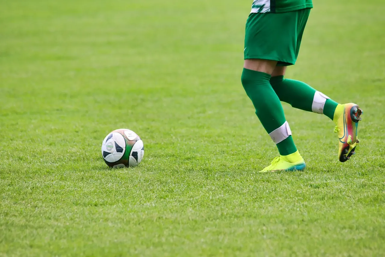 Foto de archivo: futbolista en traje en el banquillo