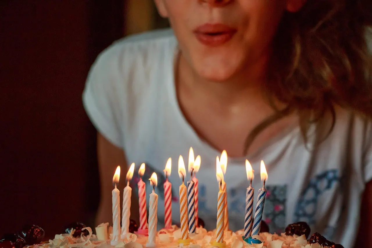 Foto de archivo: persona soplando velas de cumpleaños