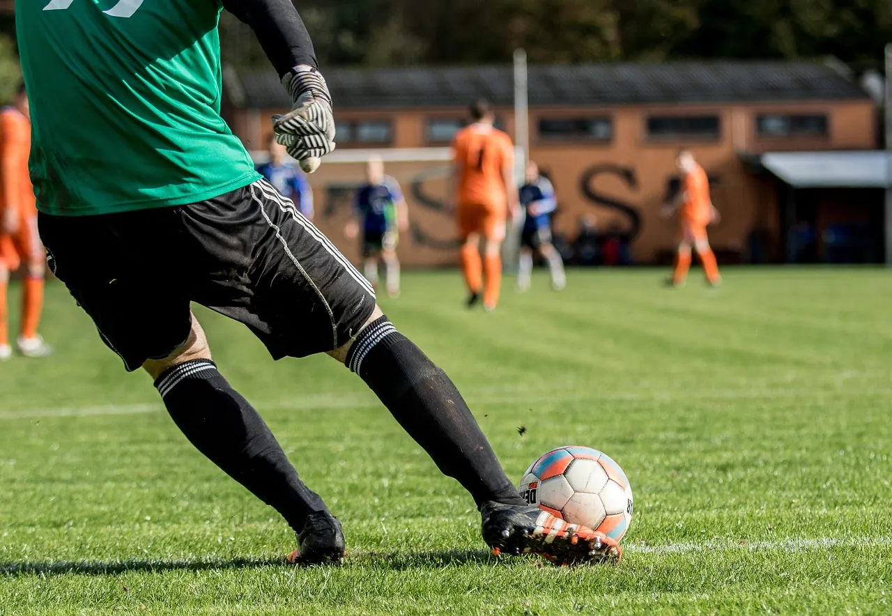 Stock photo: soccer ball deflecting off a footballer's backside