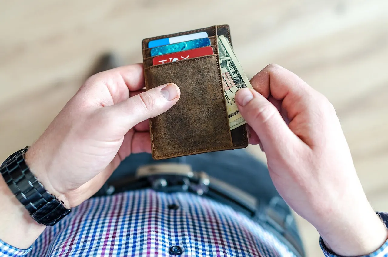 Stock photo: person holding cash from a leather wallet
