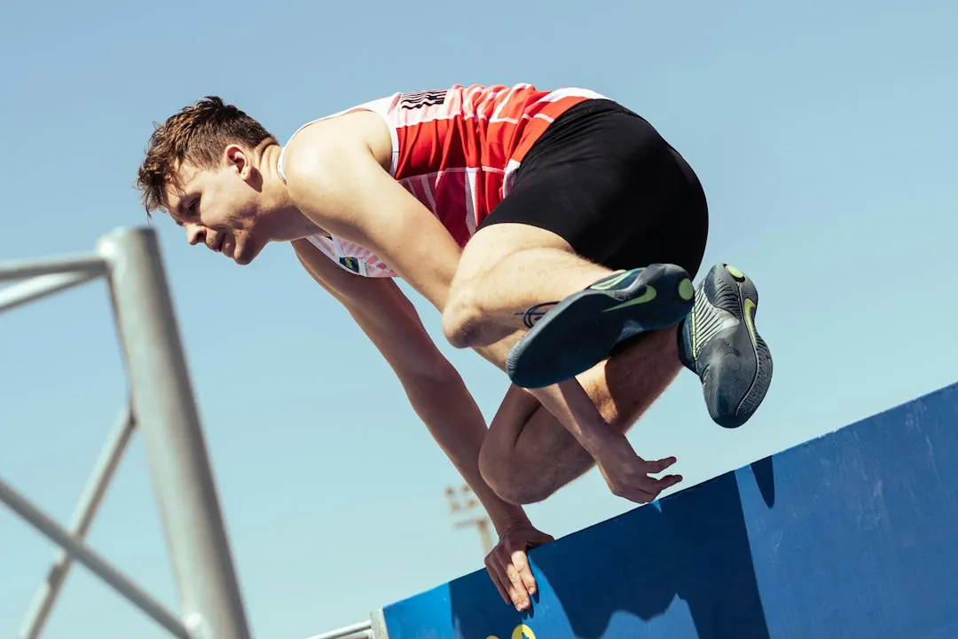 Stock photo: athlete floating high above sports field